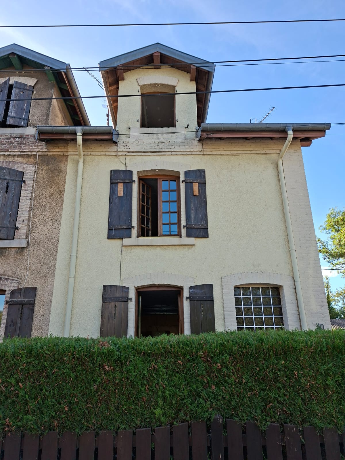 Façade avant les travaux : anciennes fenêtres en bois.